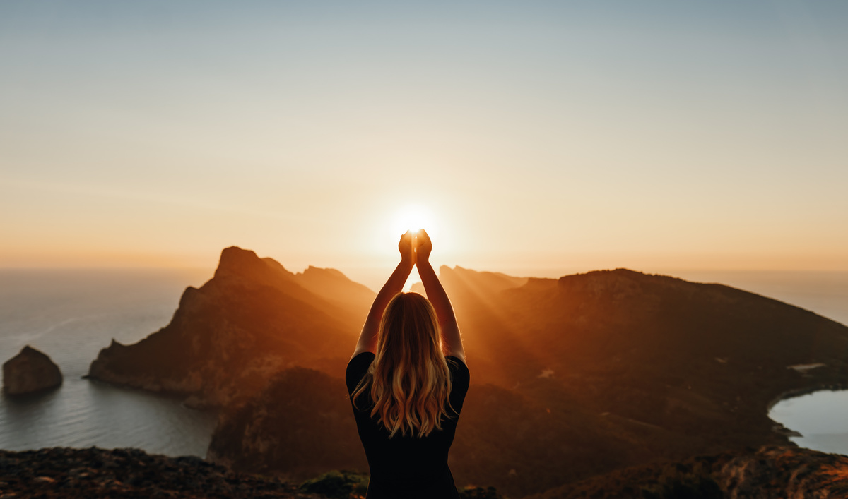 Young woman in spiritual pose holding the light